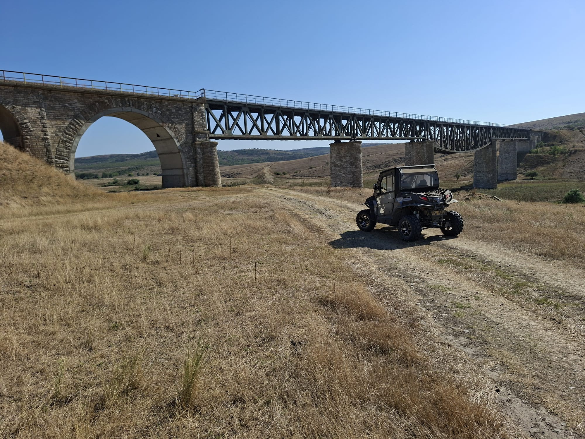 Vehicul off-road lângă un pod vechi de cale ferată