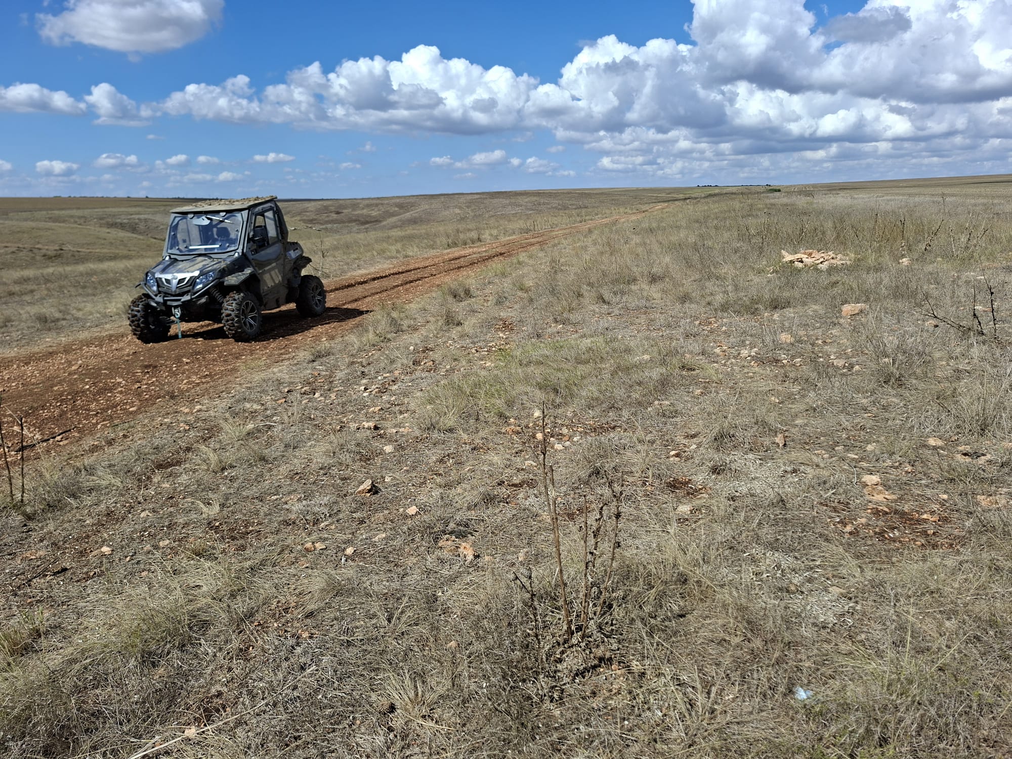Vehicul off-road pe un drum de câmp sub nori albi